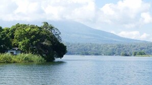 Una pareja descansando junto a una piscina con vistas a un lago y una montaña distante.