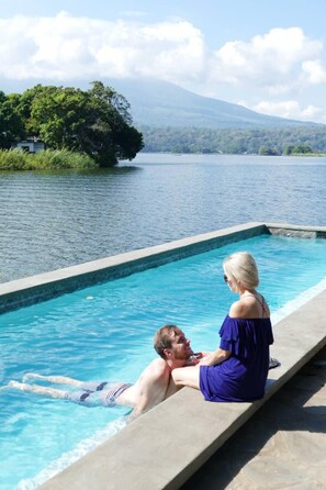 Una piscina al aire libre, sillones reclinables de piscina