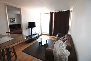 Apartamento estándar, 1 cama de matrimonio grande con sofá cama | Zona de estar | Una televisión de pantalla plana