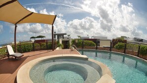 A hot tub surrounded by a wooden deck, with lounge chairs and a canopy. - Heliko 101A by CocoBR (Playa del Carmen)
