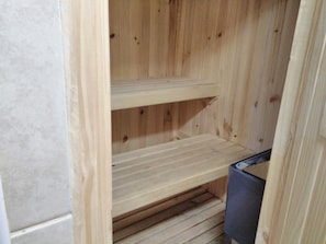 A wooden interior with a built-in bench and a trash bin.