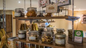 A display of various food items in glass jars on shelves. - Hôtel Mercure Paris Suresnes Longchamp (Suresnes)