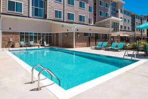 A rectangular swimming pool with a white border, surrounded by lounge chairs and a covered patio area. - Residence Inn by Marriott Decatur (Decatur)