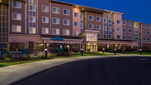 A multi-story hotel with a modern design, featuring a covered outdoor seating area and a well-lit entrance. - Residence Inn by Marriott Decatur (Decatur)