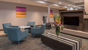 A modern hotel lobby with a seating area, a flat-screen TV, and a decorative vase. - Residence Inn by Marriott Decatur (Decatur)
