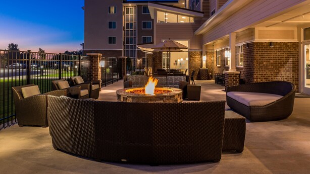 A patio with a fire pit, outdoor seating, and a view of a multi-story building. - Residence Inn by Marriott Decatur (Decatur)