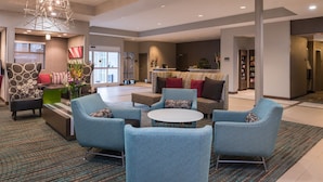 A modern lobby with seating areas, a reception desk, and a large window. - Residence Inn by Marriott Decatur (Decatur)