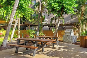 Outdoor picnic tables, a barbecue grill, and a stone planter. - WorldMark Kihei (Kihei)