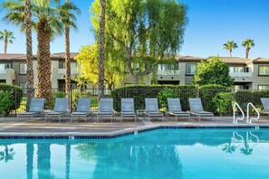 A swimming pool with lounge chairs and palm trees. - Worldmark Cathedral City (Cathedral City)