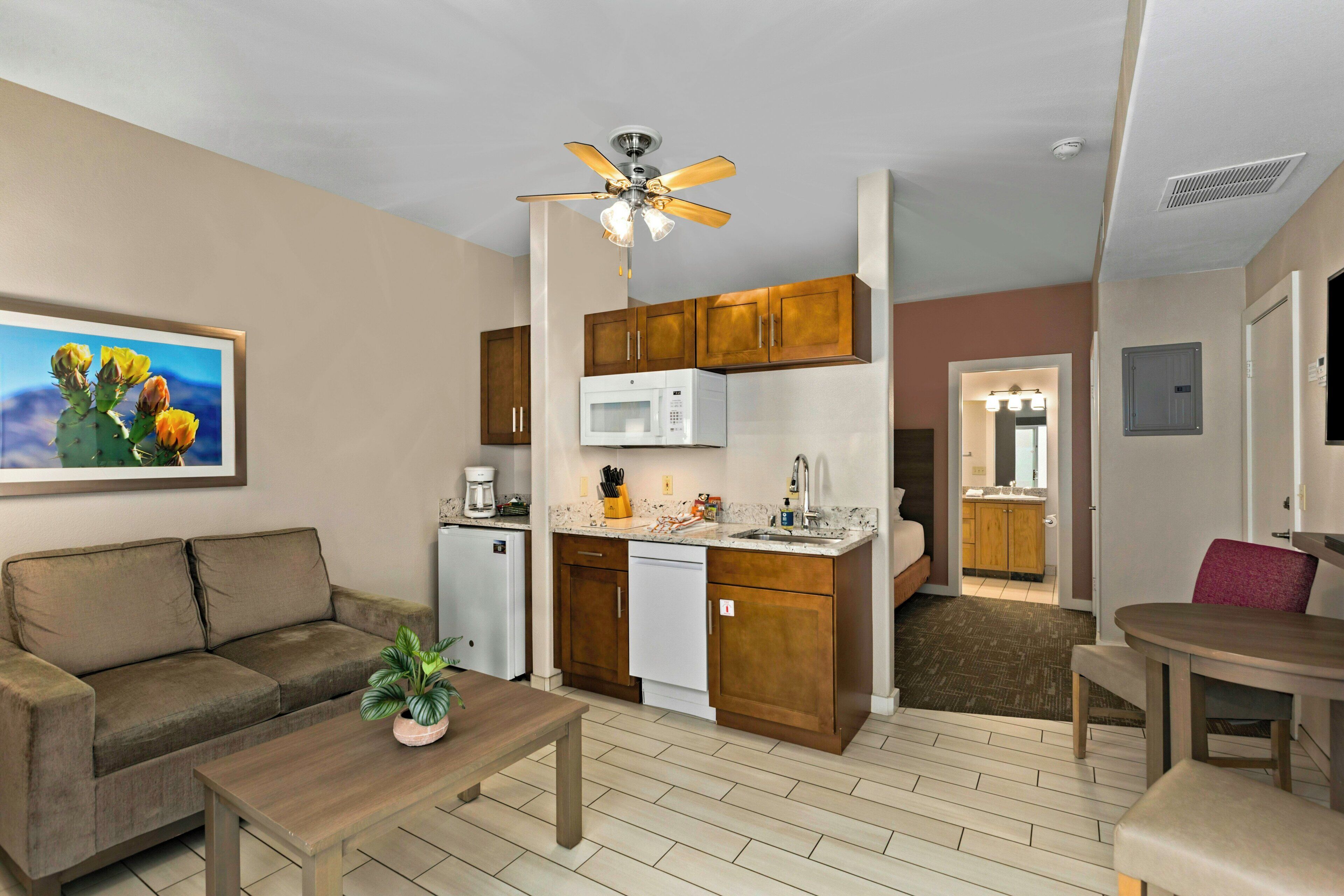 A compact living space with a kitchenette, a dining area, and a bedroom.