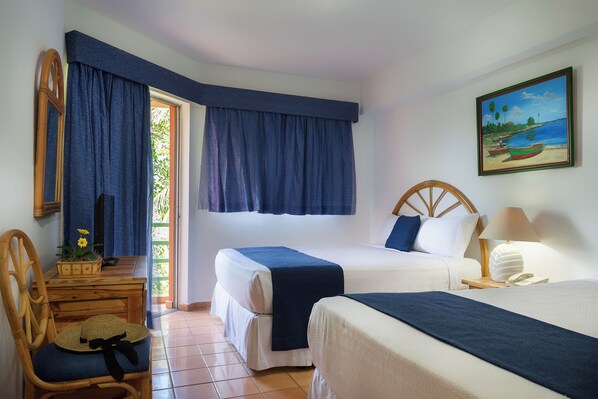 A room with two beds, a desk, a chair, a painting, and a window with curtains. - whala boca chica (Boca Chica)
