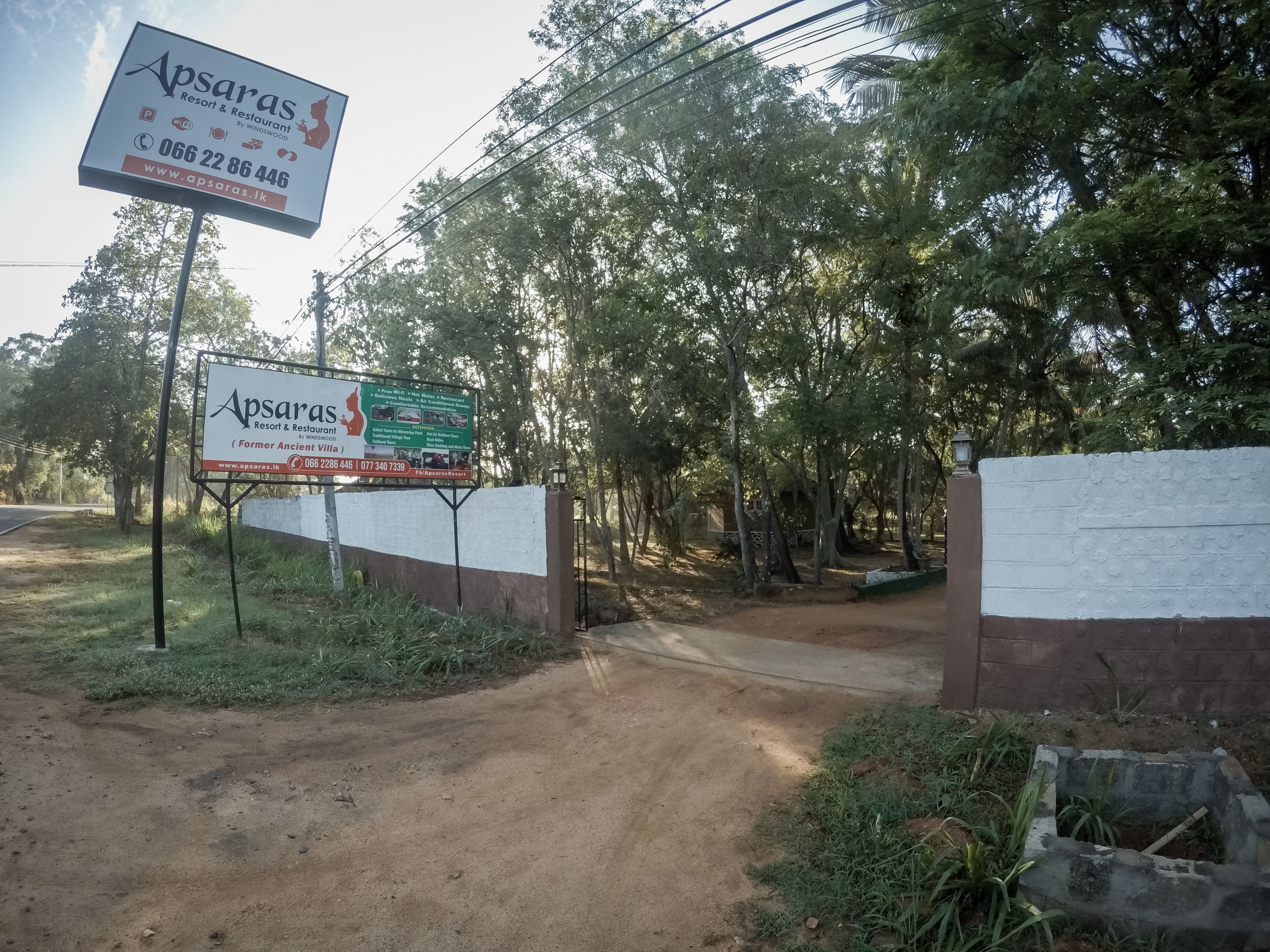 A signboard for Apsaras Resort & Restaurant with contact details and amenities listed.