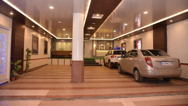 Un hall de hotel con mostrador de recepción, zona de estar y coches estacionados.