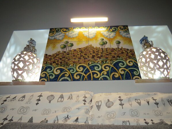 Vibrant cityscape mural adorns the wall, complemented by geometric light fixtures and a colorful patterned fabric.