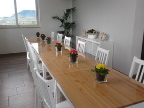 Enjoy meals with family and friends in this spacious dining area, surrounded by lush greenery and a beautiful mountain view.