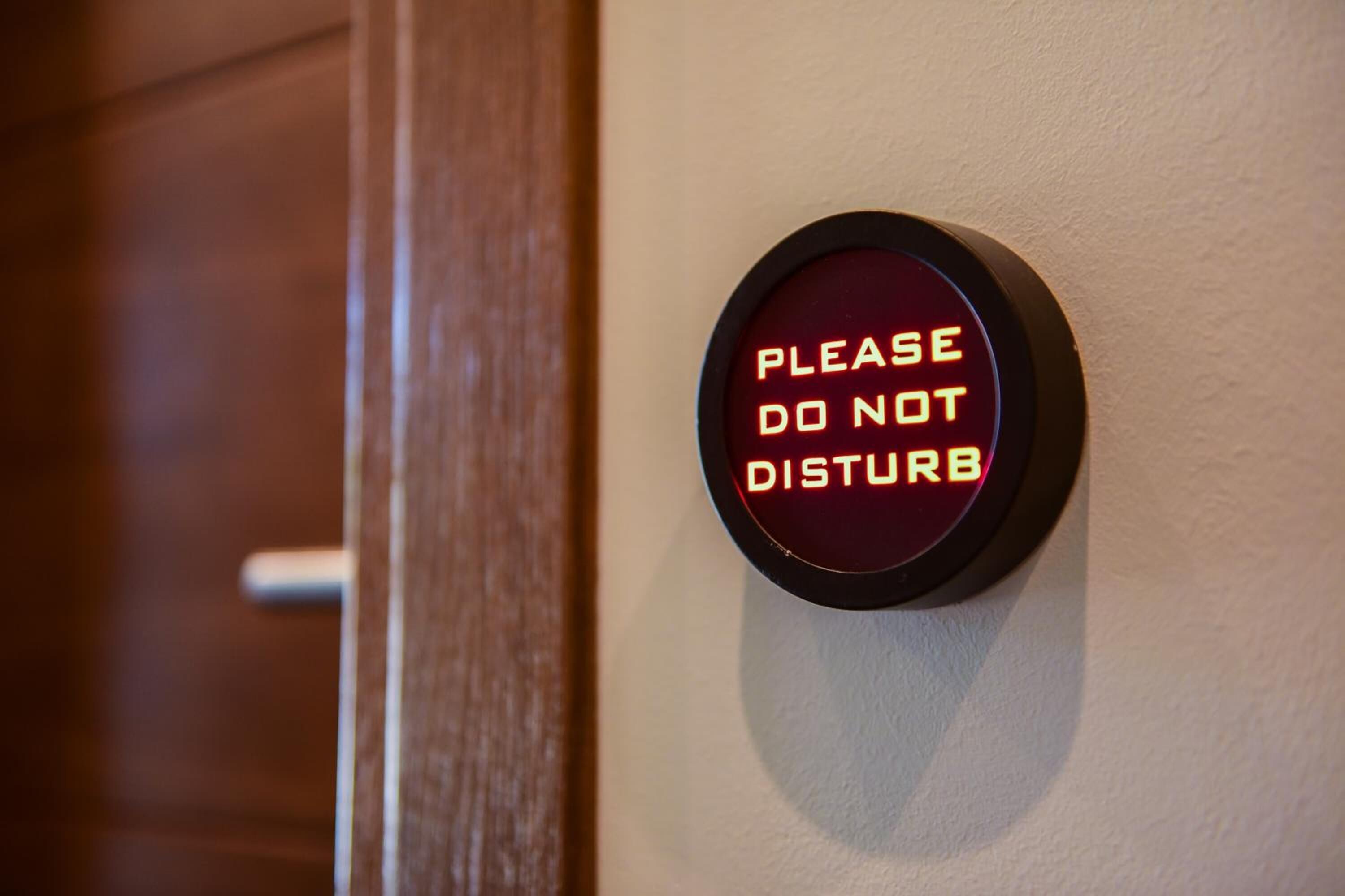 A wall-mounted sign with the text "PLEASE DO NOT DISTURB" in a circular frame.