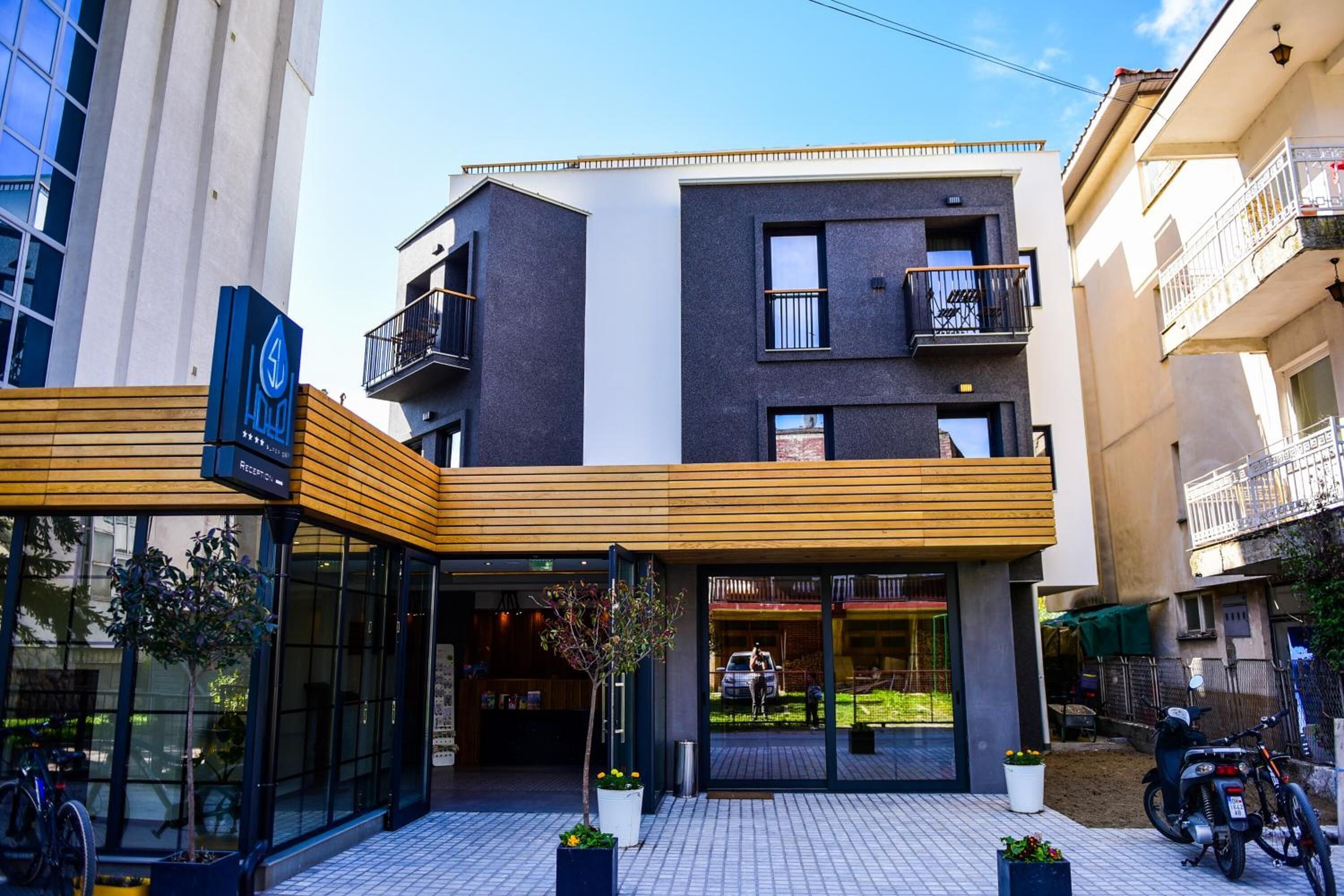 A modern hotel with a wooden facade, large windows, and a balcony.