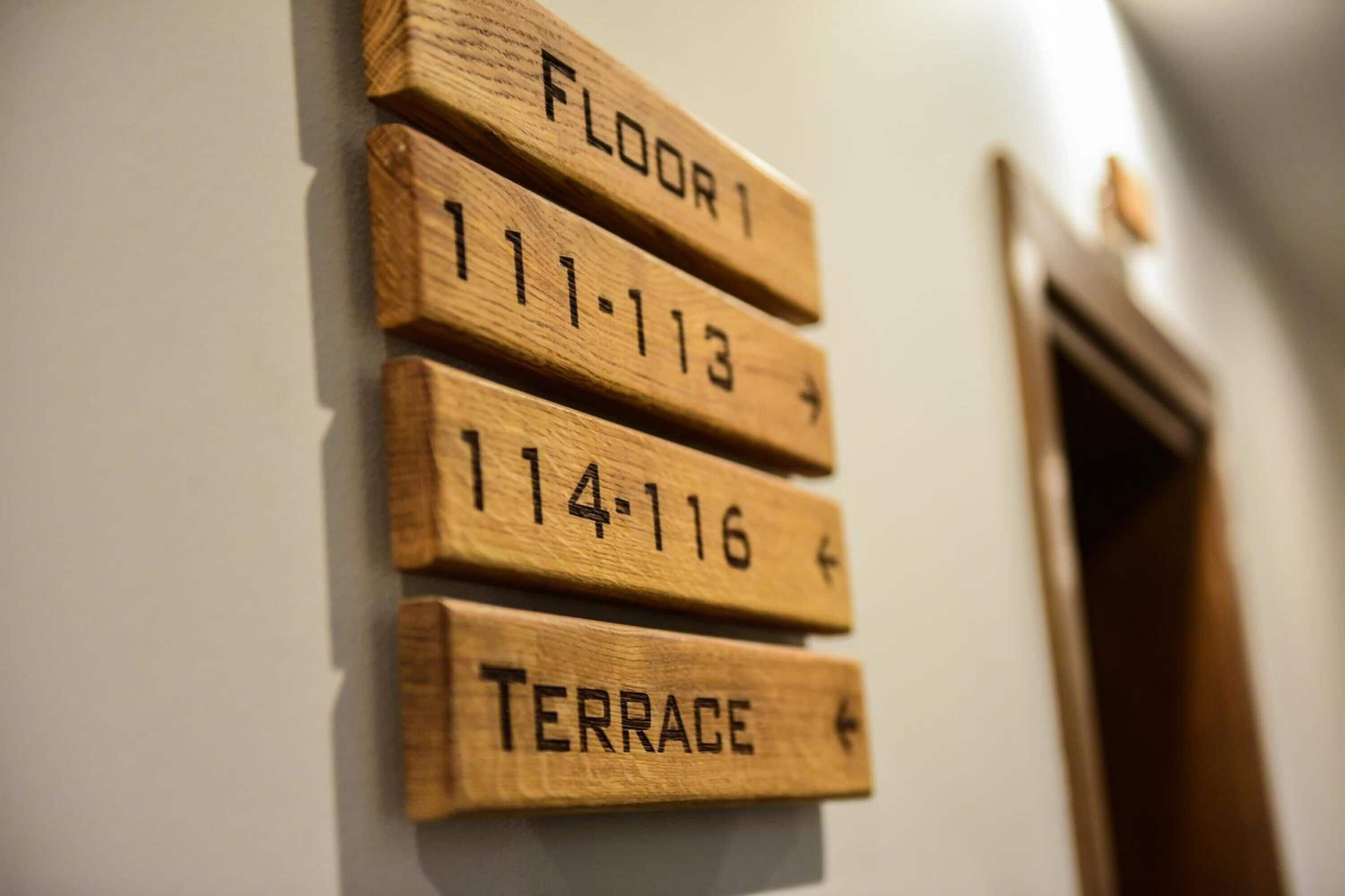 Wooden signs indicating room numbers and a terrace.