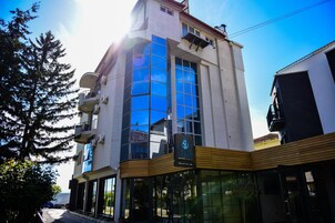 Un edificio moderno con amplios ventanales de vidrio, una recepción y un balcón.