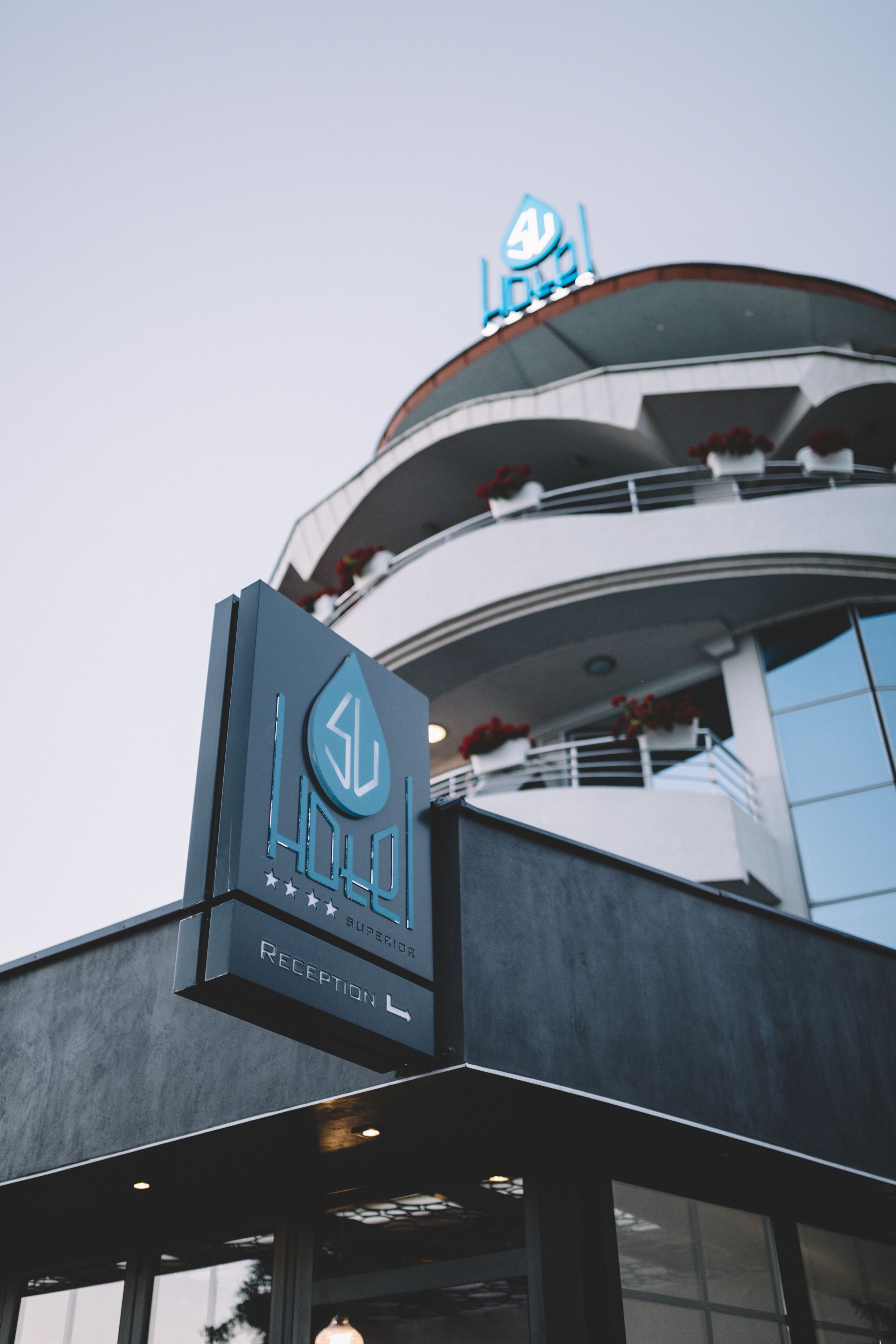 A hotel reception sign with a modern design and a logo.