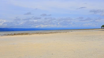 A beach with a clear sky and distant mountains.