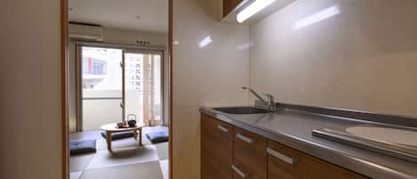 A kitchen with wooden cabinets, a stainless steel sink, and a sliding door leading to a balcony.