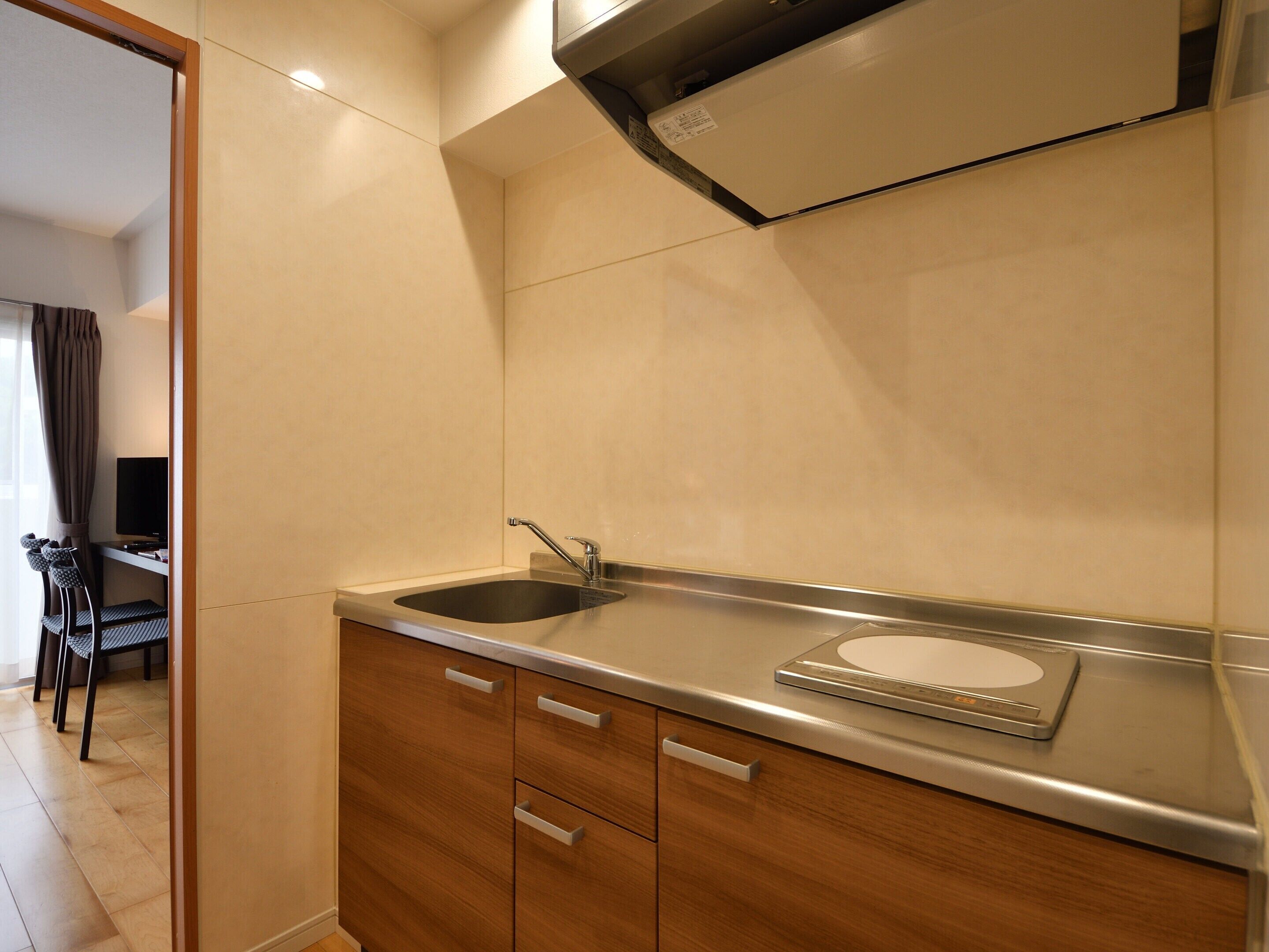 A modern kitchen with a sink, a scale, and wooden cabinets.