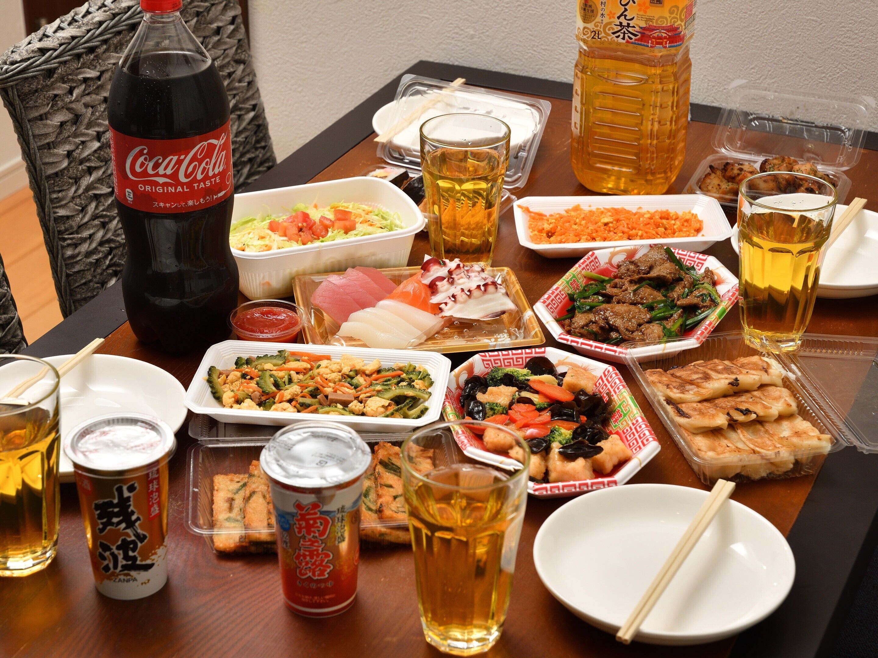 A table with various food items, drinks, and a Coca-Cola bottle.