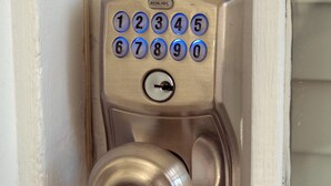 A metallic door lock with a numeric keypad and a keyhole.