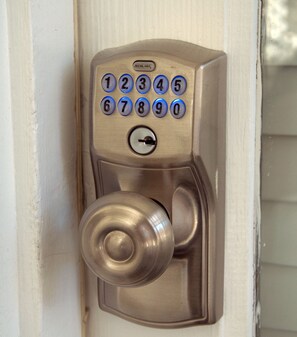 A metallic door lock with a numeric keypad and a keyhole.
