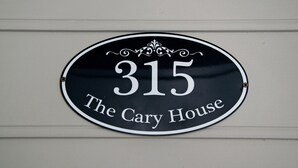 A black and white house number sign with the text "315 The Cary House" on a white wall.
