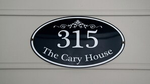 A black and white house number sign with the text "315 The Cary House" on a white wall.