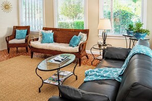 A living room with a sofa, two armchairs, a coffee table, and a lamp.