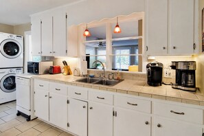 A modern kitchen with built-in appliances, a sink, and a coffee maker.