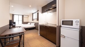 A compact hotel room with a kitchenette, a bed, a desk, and a TV. - Le Studio Gojo Takakura (Kyoto)