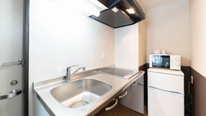 A compact kitchen with a stainless steel sink, a microwave, and a built-in oven. - Le Studio Gojo Takakura (Kyoto)