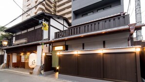 A traditional Japanese building with a wooden entrance, a green awning, and a sign above the door. - Le Studio Gojo Takakura (Kyoto)