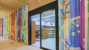 A store with colorful curtains and a sign that reads "Discover Snacks & Sundries."