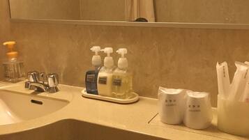 A bathroom with a sink, mirror, and toiletries.