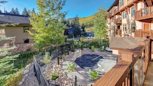 A residential area with a swimming pool, wooden deck, and surrounding trees. - Pristine Ski Retreat, Slope Views in Solitude Village, 2 Bedroom, 2 Bath (Solitude)