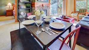 A dining area with a table set for four, a fireplace, and a view of the outdoors. - Pristine Ski Retreat, Slope Views in Solitude Village, 2 Bedroom, 2 Bath (Solitude)