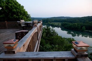 A wooden deck overlooking a river with a view of the surrounding greenery and hills. - Private Dock, Fishing, Hiking, Fire Pit, Hot Tub, Lakeview Haven on 8+ acres (Branson)