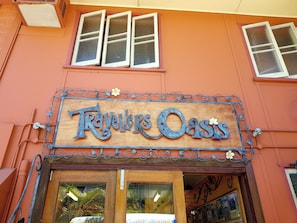 A storefront with a sign reading "Travelers Oasis" and a wooden door. - Travellers Oasis - Hostel (Parramatta Park)