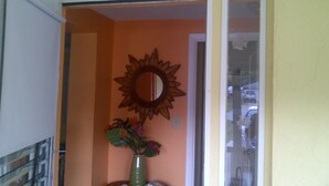 A room with a sunburst mirror, a welcome sign, and a vase with flowers. - Old Florida Charm, quiet, close to beach and boat launch. (Englewood)