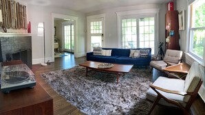 Un salon avec un canapé bleu, une table basse et une cheminée.