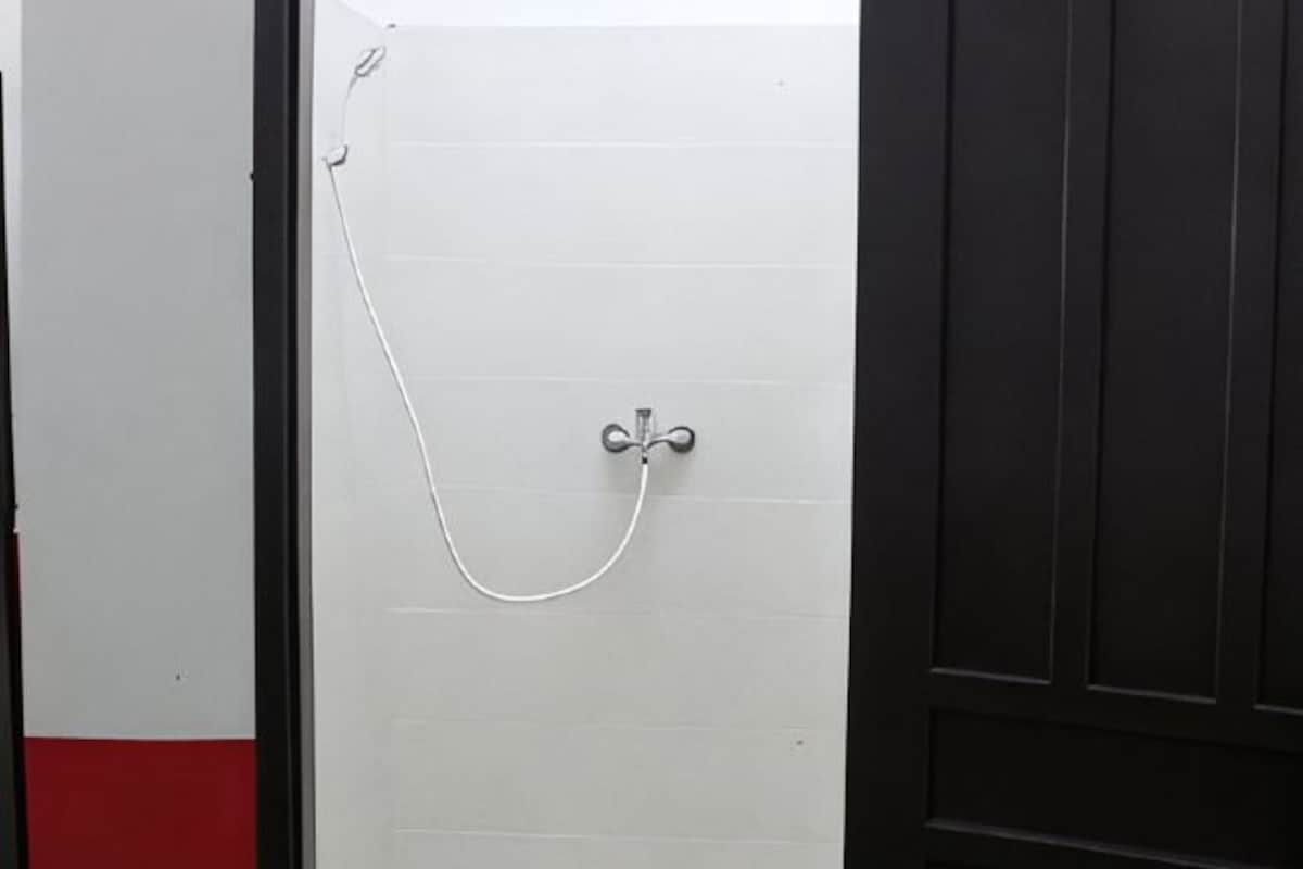 A door with a shower head and hose.