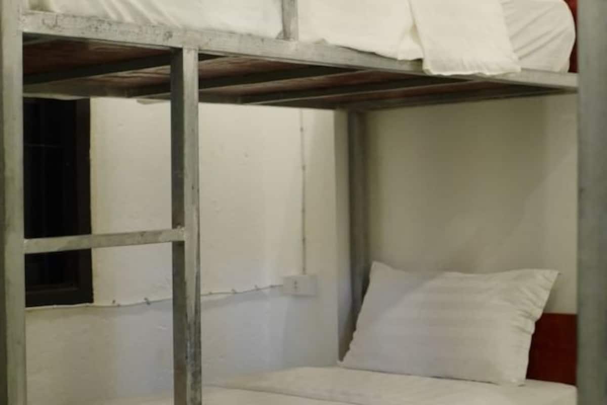 A bunk bed with a single mattress and a pillow.