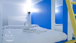 A single bed with white bedding and a swan-shaped pillow arrangement. A ladder is visible to the right. - Hua Hin Night Market Hostel (Hua Hin)