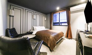 A hotel room with a bed, a desk, a chair, and a window with curtains. - A-VANT HOTEL (Cheonan)