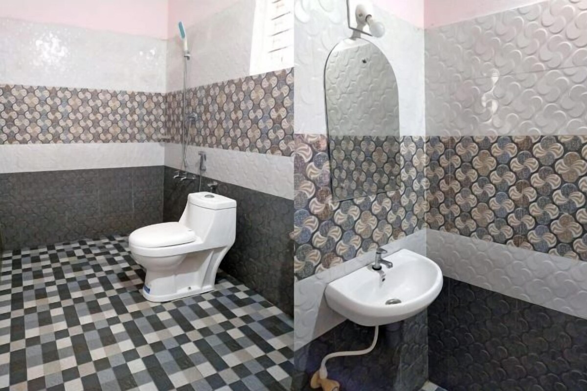A bathroom with a checkered floor, a toilet, a sink, and patterned walls.